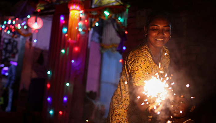 A woman and her son hold firecrackers during Diwali, the Hindu festival of lights, in Mumbai, India, November 4, 2021. — Reuters