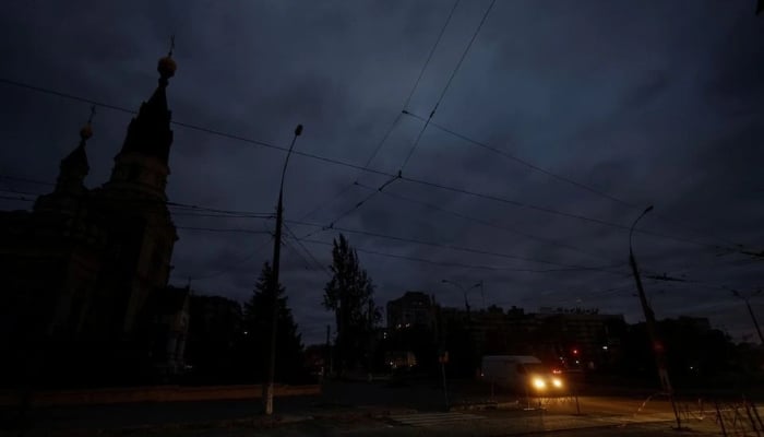 20 اکتوبر 2022 کو یوکرین کے میکولائیو میں، یوکرین پر روس کے حملے کے دوران، ایک وین بجلی کی کمی کے دوران ایک تاریک گلی میں چل رہی ہے۔ - رائٹرز