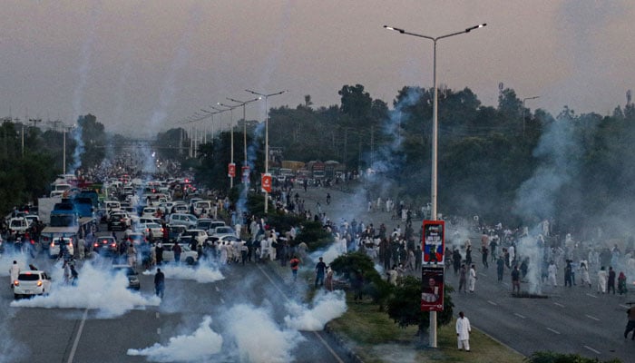 Police use teargas to disperse protestors of PTI during a demonstration against the decision to disqualify former prime minister Imran Khan running for political office, in Islamabad on October 21, 2022. — AFP