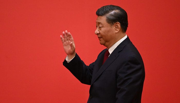 Chinas President Xi Jinping waves as he arrives with members of the Chinese Communist Partys new Politburo Standing Committee, the nations top decision-making body, as they meet the media in the Great Hall of the People in Beijing on October 23, 2022. — AFP