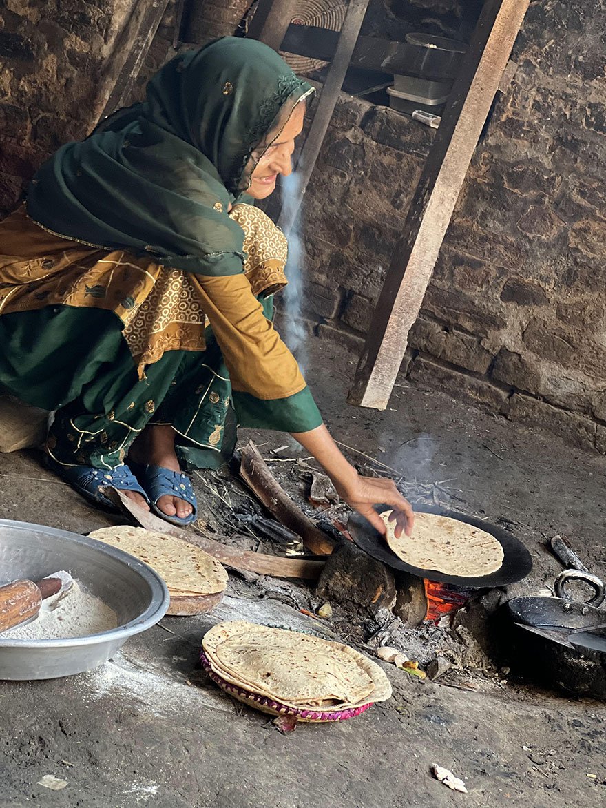 Naheed Solangi, 60, makes flatbread on a griddle placed on a firewood mud stove in a corner of her flood-destroyed house in a village in Sindh’s Khairpur district. — Helpage