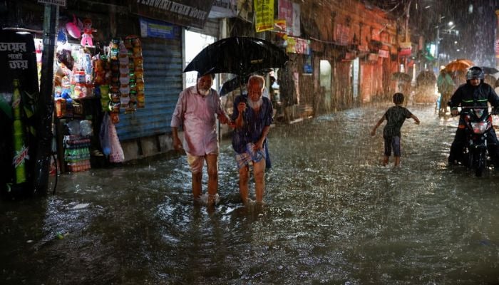People wade through a flooded street amid continuous rain before the Cyclone Sitrang hits the country in Dhaka, Bangladesh, October 24, 2022.— Reuters