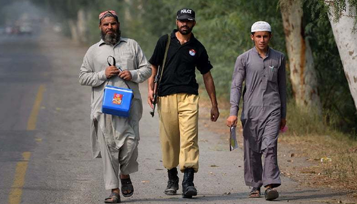 A policeman accompanies polio workers on a polio immunisation campaign. — Reuters/File