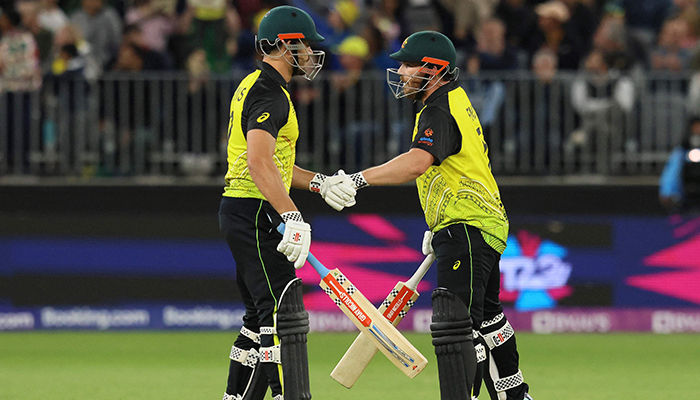 Australias Aaron Finch (R) and Marcus Stoinis bump gloves during the ICC mens T20 World Cup 2022 cricket match between Australia and Sri Lanka at Perth Stadium on October 25, 2022 in Perth. — AFP