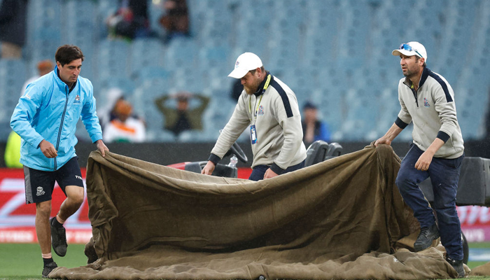 Stadium personnel cover the pitch at the Melbourne Cricket Ground after rain washes out the New Zealand vs Afghanistan clash, on October 26, 2022. — Twitter/ICC