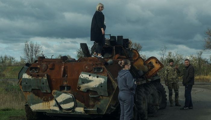 A woman stands atop a destroyed Russian BTR-82A armoured personnel carrier in a village near a frontline in Mykolaiv region, Ukraine October 26, 2022.— Reuters