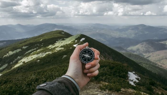 Person holding a compass at Carpathian Mountains.— Unsplash