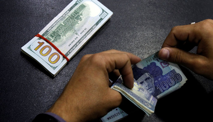 A currency trader counts Pakistani Rupee notes as he prepares an exchange of U.S dollars in Islamabad, Pakistan December 11, 2017. — Reuters/File