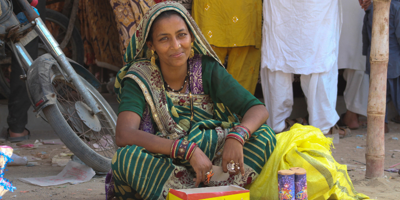 Mona, who sells firecrackers and sparklers, sits beside her makeshift stall. — Photo by author