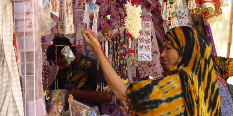 A woman looks on at decorative items at a stall. — Photo by author