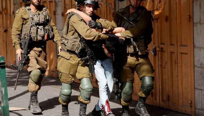 Israeli soldiers detain an injured Palestinian during clashes following a deadly Israeli raid in Nablus, in Hebron in the Israeli-occupied West Bank October 25, 2022.— Reuters