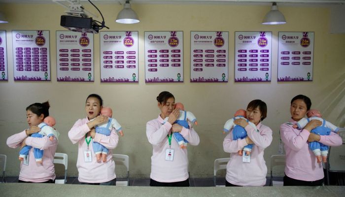 Students at Ayi University, a training program for domestic helpers, practice on baby dolls during a course teaching childcare in Beijing, China December 5, 2018.— Reuters