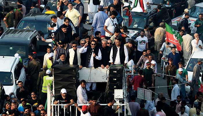 پاکستان کے سابق وزیر اعظم عمران خان (سی) 28 اکتوبر 2022 کو لاہور میں قبل از وقت انتخابات کا مطالبہ کرنے کے لیے اسلام آباد کی طرف حکومت مخالف لانگ مارچ کے دوران اپنے حامیوں سے خطاب کر رہے ہیں۔ — اے ایف پی/فائل