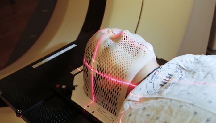 (Representational) Lasers are used to position a patient model wearing a short face mask in a computed tomography (CT) scanner to obtain images of a tumour before radiation therapy.— Unsplash