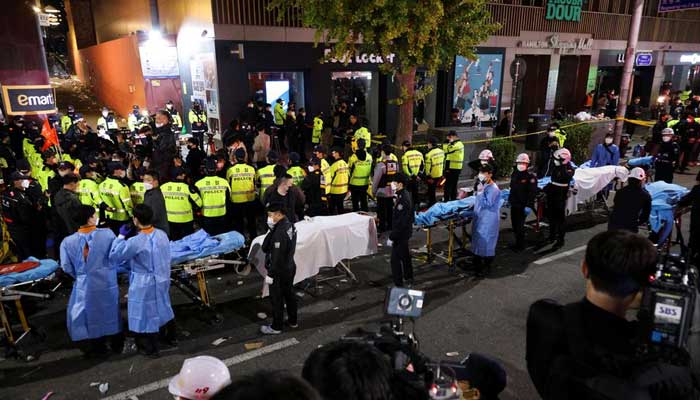 Rescue team members wait with stretchers to remove bodies from the scene where dozens of people were injured in a stampede during a Halloween festival in Seoul, South Korea, October 29, 2022. — Reuters