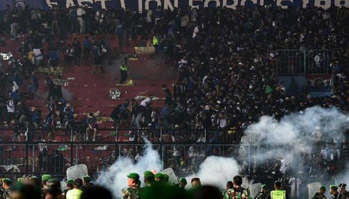 Security personnel (lower) on the pitch after a football match between Arema FC and Persebaya Surabaya at Kanjuruhan stadium in Malang, East Java on October 1, 2022. — AFP/File