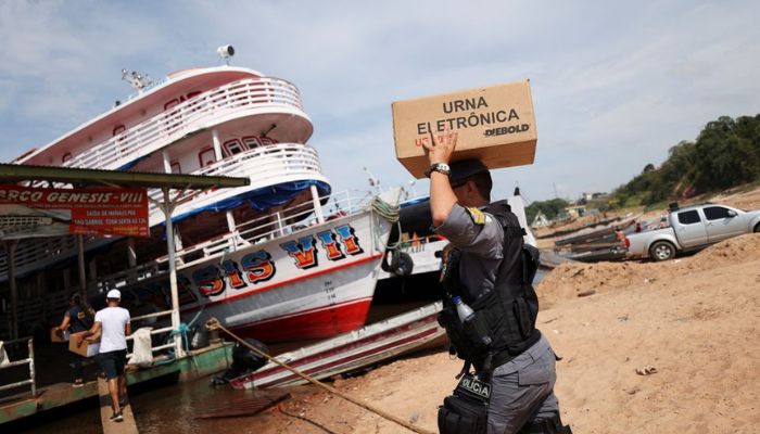 A police officer carries an electronic ballot box to voting polling stations of a community of ribeirinhos (forest dwellers), ahead of Brazilian elections, in Sao Raimundo Port, in Manaus, Brazil October 29, 2022.— Reuters