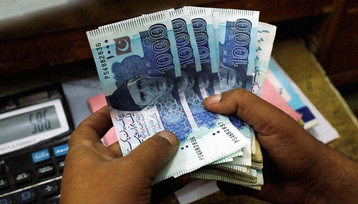 A trader counts Pakistani rupee notes at a currency exchange booth in Peshawar, Pakistan, December 3, 2018. — Reuters