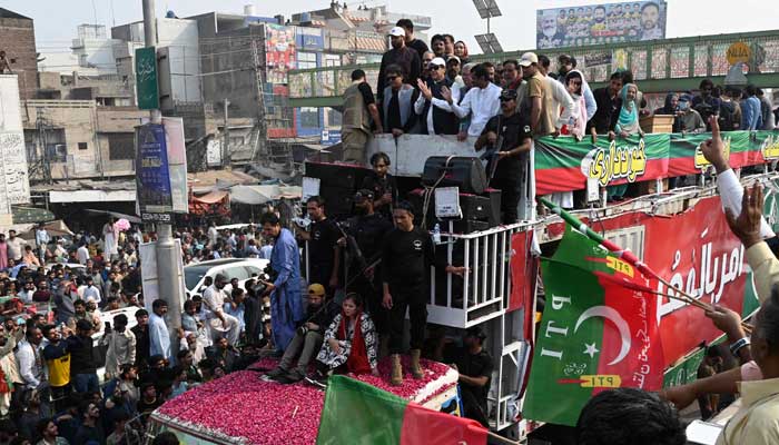 Pakistans former prime minister Imran Khan (C top) gestures to his supporters during an anti-government march towards Islamabad city, demanding early elections, in Muridke district, about 29 km from Lahore on October 30, 2022. — AFP