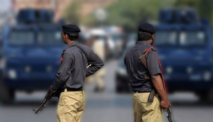 Police stand guard near a crime scene in Karachi. — Reuters/File