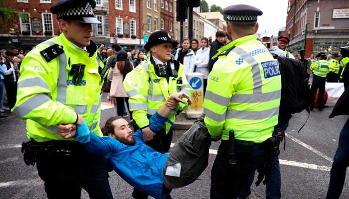 Police officers apprehend a protester blocking a road in London, UK, on October 30, 2022. — Reuters