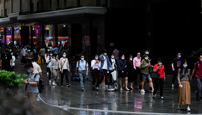 People wearing protective face masks walk on a street, following the coronavirus disease (COVID-19) outbreak, in Shanghai, China, September 28, 2022. — Reuters