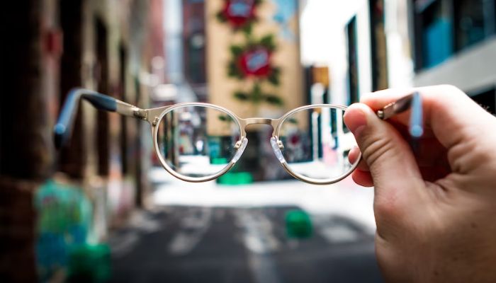 A person holding spectacles.— Unsplash