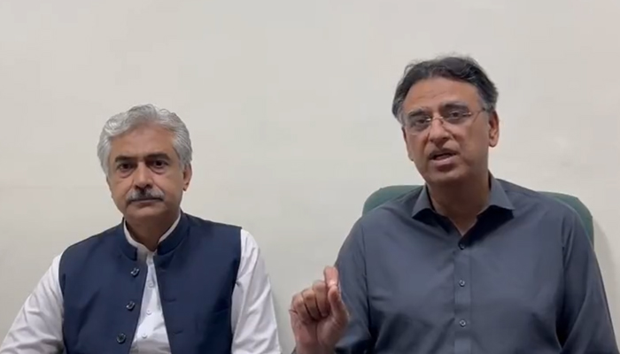 PTI Secretary-General Asad Umar (left) speaks during a video message following an attack on party chairman Imran Khan, on November 3, 2022. — Twitter/PTI