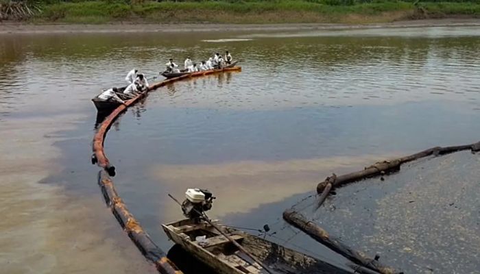 Workers attempting to stop the flow of oil in the Cuninico River in September following the spill.— AFP