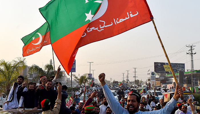 اپوزیشن جماعت پاکستان تحریک انصاف (پی ٹی آئی) کے کارکن 28 اکتوبر 2022 کو پشاور میں قبل از وقت انتخابات کا مطالبہ کرنے والی حکومت مخالف ریلی میں حصہ لے رہے ہیں۔ — اے ایف پی