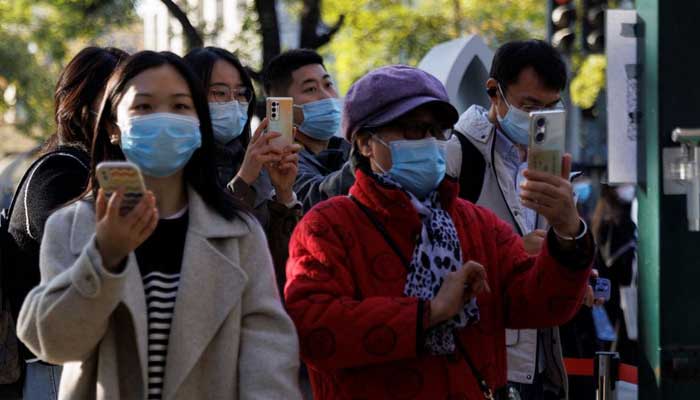 People scan their health codes before entering a fenced-off street as outbreaks of the coronavirus disease (COVID-19) continue in Beijing, China November 5, 2022. — Reuters