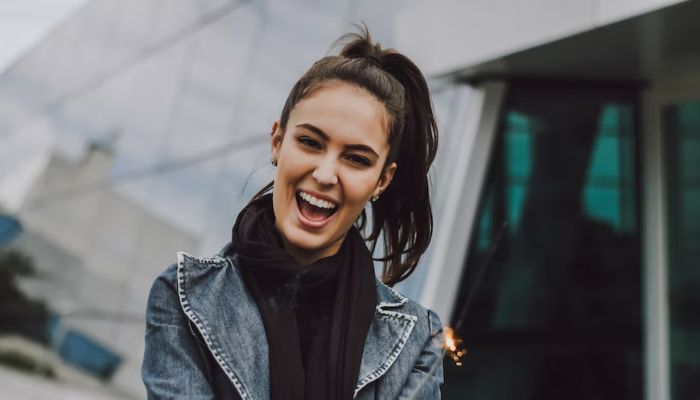 A woman smiles at the camera.— Unsplash