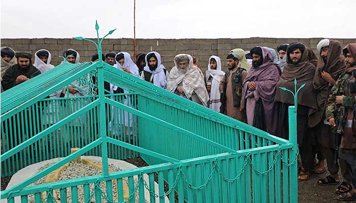 This handout photograph taken on November 6, 2022 and released by the Taliban Government shows the members of the Taliban standing next to the tomb of late Afghan Taliban leader Mullah Omar, at Omarzo in Suri district of Zabul province. — AFP