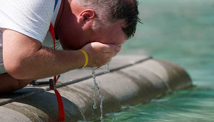 Man splashes water on face to cool down. — Twitter