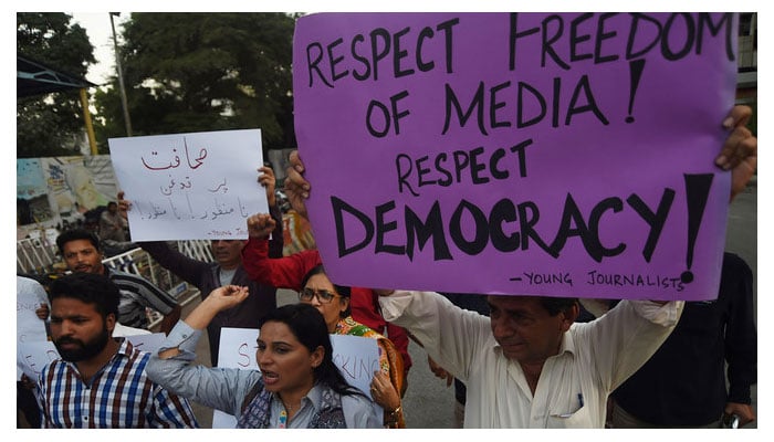 Pakistani journalists and civil society activists hold placards against the attack on a senior journalist of a local newspaper in Karachi on October 28, 2017. — AFP