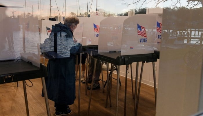 Lake Ogleton is reflected in the window as voters cast their ballots in midterm elections at the Bay Ridge Civic Association, in Annapolis, Maryland, U.S., November 8, 2022.— Reuters