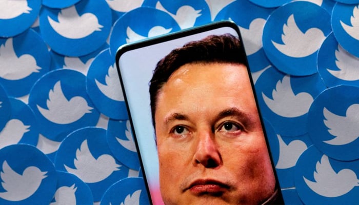 An image of Elon Musk is seen on a smartphone placed on printed Twitter logos in this picture illustration taken April 28, 2022. — Reuters