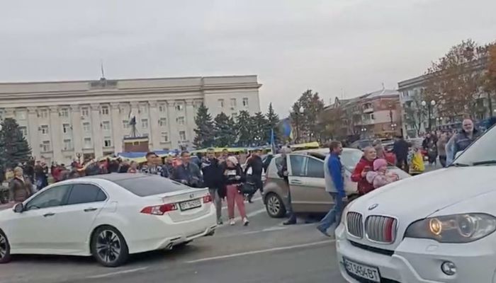Crowd cheer and chant as they surround a car with Ukrainian soldiers in Kherson Freedom Square, Ukraine in this screen grab obtained from a video released on November 11, 2022.— Screengrab via Reuters