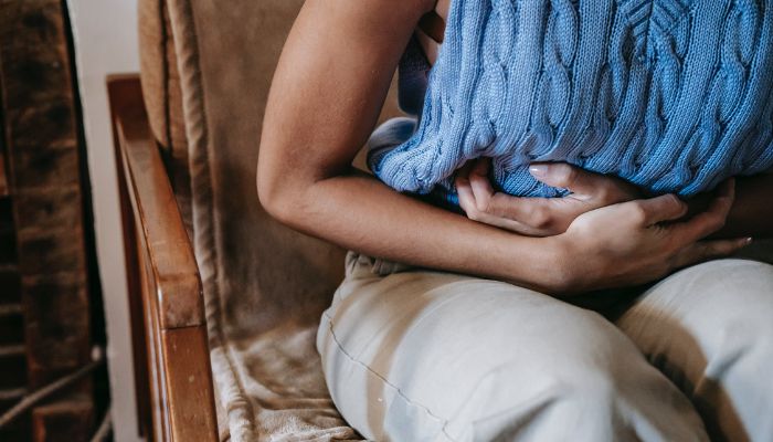 A woman suffering from stomach pain.— Pexels