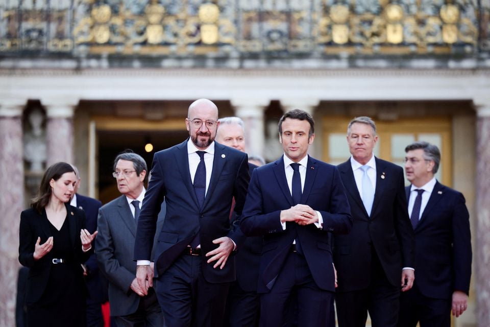 French President Emmanuel Macron, European Council President Charles Michel and EU leaders arrive for a family photo during an informal summit at the Chateau de Versailles.— Reuters