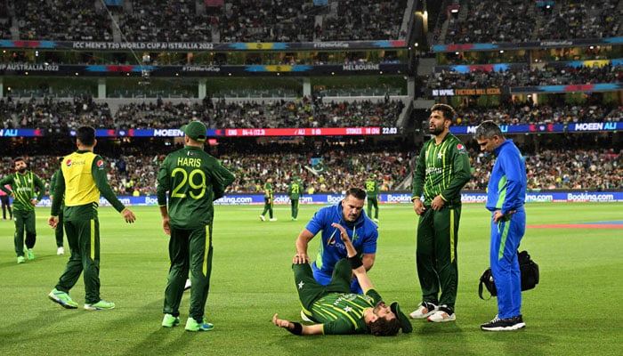 Shaheen Shah Afridi (C) lies on the ground as he receives treatment after injury during the ICC men´s Twenty20 World Cup 2022 final between England and Pakistan at The Melbourne Cricket Ground (MCG) in Melbourne on November 13, 2022. — AFP