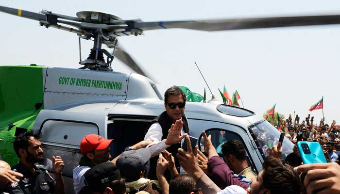 Pakistans ousted prime minister Imran Khan (C) arrives on a helicopter to lead a protest rally in Swabai on May 25, 2022. — AFP