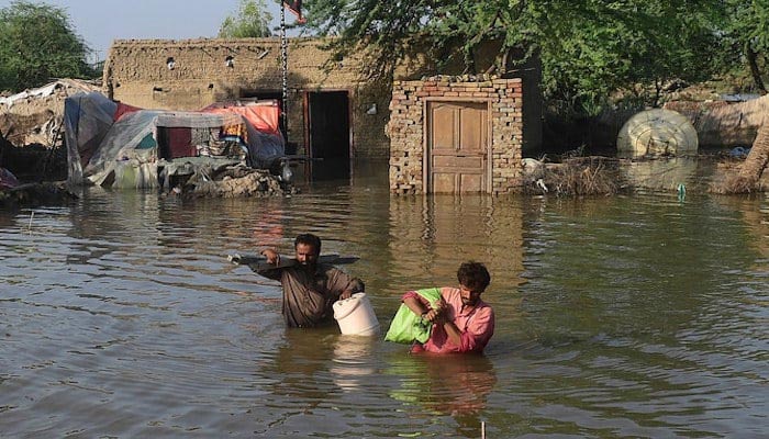 Flood affected people carry belongings out from their flooded home in Shikarpur, Sindh province, on August 31, 2022. — AFP/File