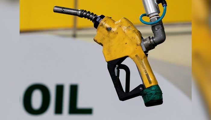 In this file photograph, a gas pump is seen hanging from the ceiling at a petrol station. — Reuters/File