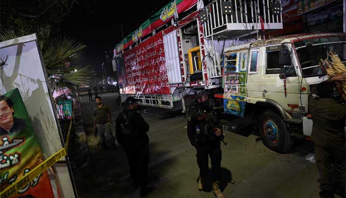 Police officers stand guard in front of container truck used by the former Pakistani prime minister Imran Khan during his political rallies, hours after a gun attack in Wazirabad on November 3, 2022. — AFP/File