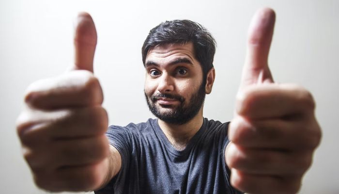 A man posing with thumbs up to the camera.— Unsplash