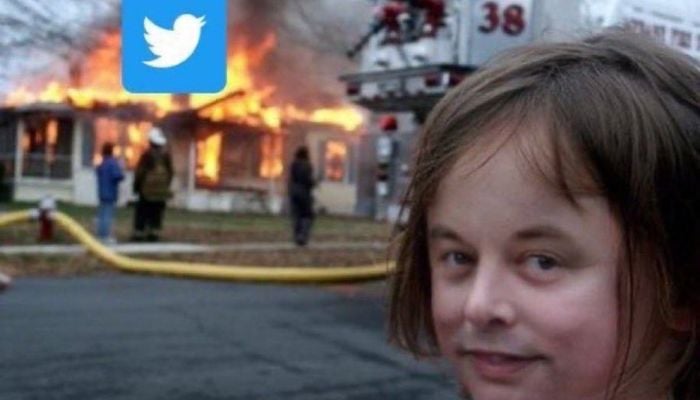 The image shows Elon Musks face edited on a famous meme where a little girl wears an evil smile while a house burns behind her.— Twitter