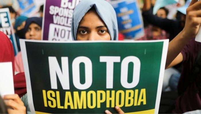 A citizen holds a placard during a peace vigil organised by citizens against what they say is rise in hate crimes and violence against Muslims in the country, in New Delhi, India, April 16, 2022.— Reuters