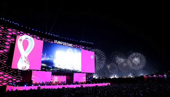 General view of fans at a stage during the opening of the FIFA fan festival as fireworks explode in the background. — Reuters