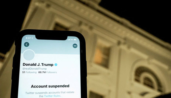 A photo illustration shows the suspended Twitter account of US President Donald Trump on a smartphone and a lit window in the White House residence in Washington, US, January 8, 2021. — Reuters